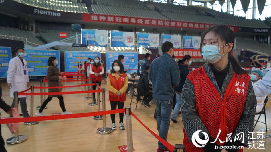 下關(guān)街道團(tuán)干部何文惠在維護(hù)現(xiàn)場秩序、引導(dǎo)登記接種。張文軒攝