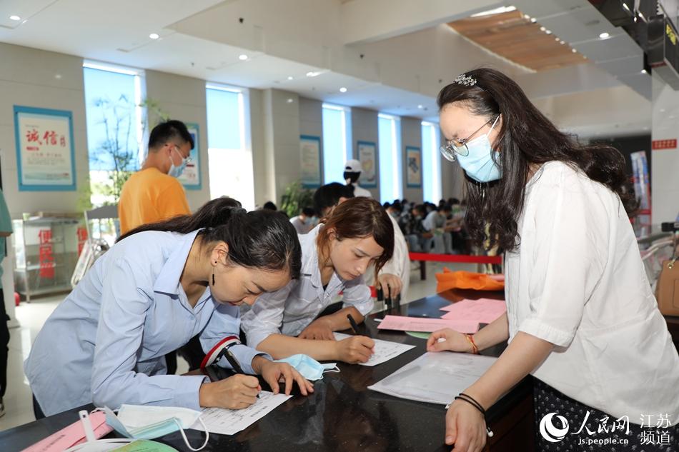 高校畢業(yè)生在招聘會現(xiàn)場報名登記。顧建攝