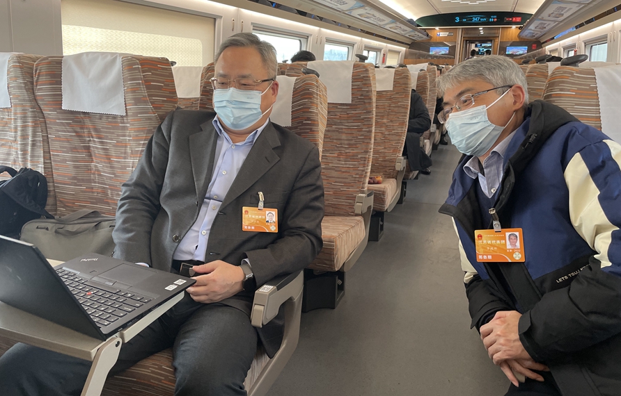 赴京參會(huì)途中，全國(guó)人大代表交流建議修改情況