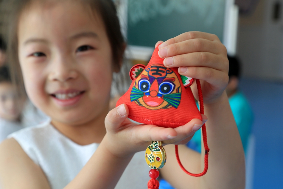 贛榆區(qū)早教中心里，孩子展示新做的荷包。邵世新攝