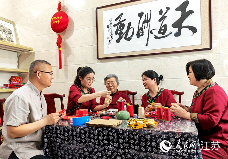 王秀英老人指導(dǎo)孫女制作香包。人民網(wǎng) 閆峰攝