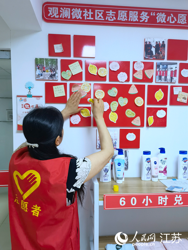 連云港灌南縣觀瀾名苑小區(qū)志愿者把居民的微心愿張貼在微心愿墻上。人民網(wǎng) 黃啟源攝
