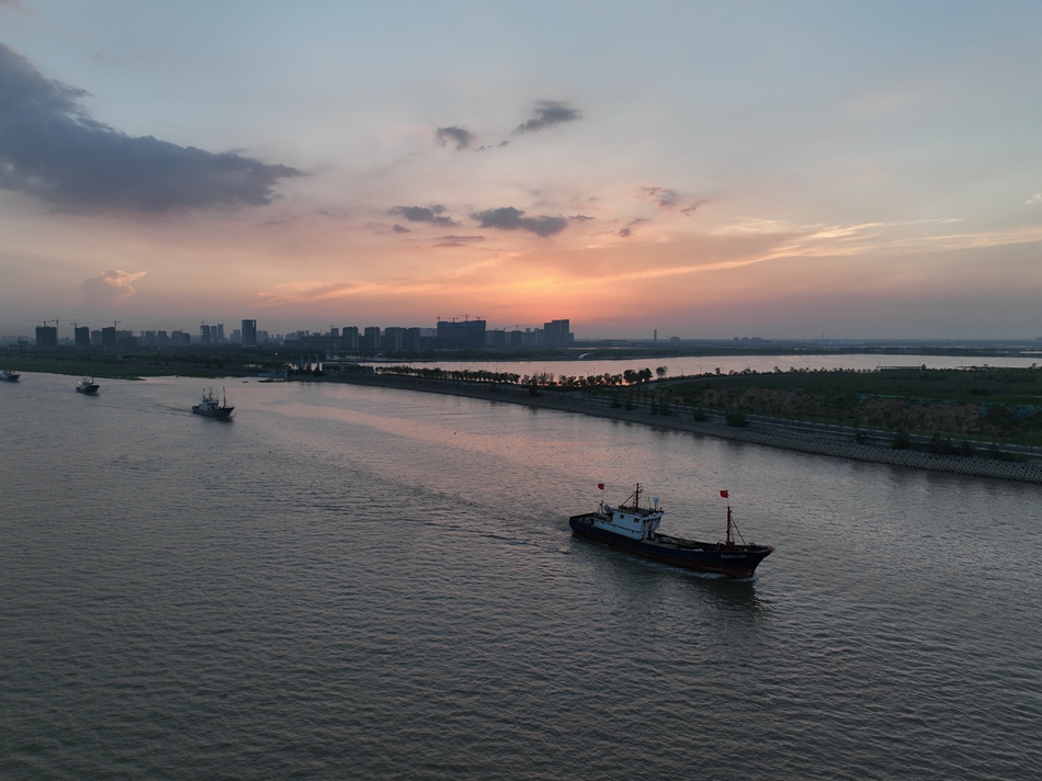 晚霞映照下，連云港贛榆漁船依次駛離海港。榆宣攝