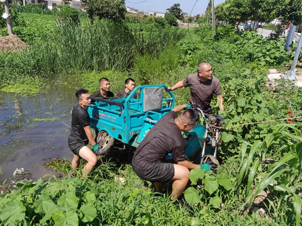 圖為退伍老兵趙國能（右上）和海警隊(duì)員合力將落水老人三輪車推上岸。灌南縣委宣傳部供圖