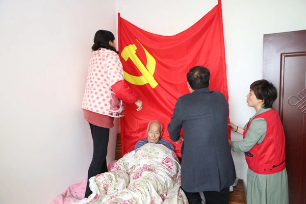 志愿者為曹加常身后布置黨旗。受訪者供圖