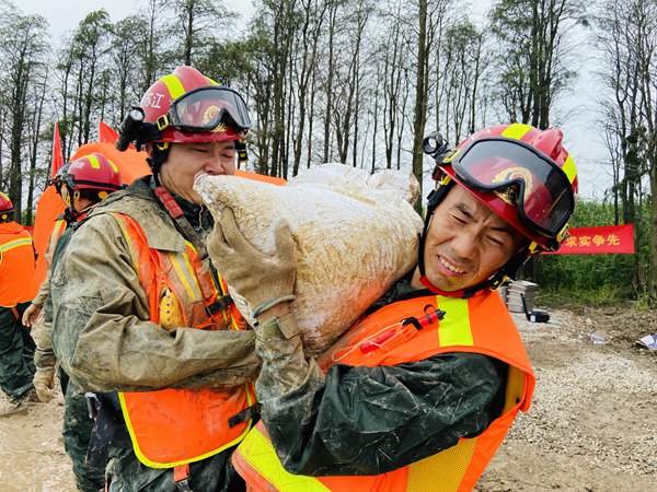 陳新寬在抗洪救援現(xiàn)場(chǎng)（右一）?；窗矃^(qū)委宣傳部供圖