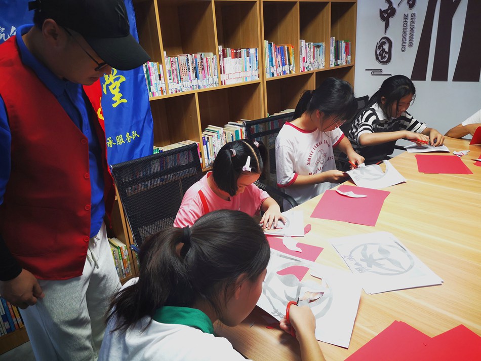 孩子們學(xué)習(xí)剪紙技藝。史道智攝