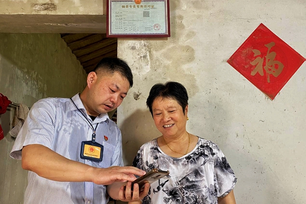 工作人員高溫天氣上門服務(wù)老年商戶。溧水煙草供圖