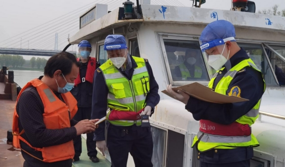 執(zhí)法人員進(jìn)行查驗(yàn)、測(cè)溫、登記工作。