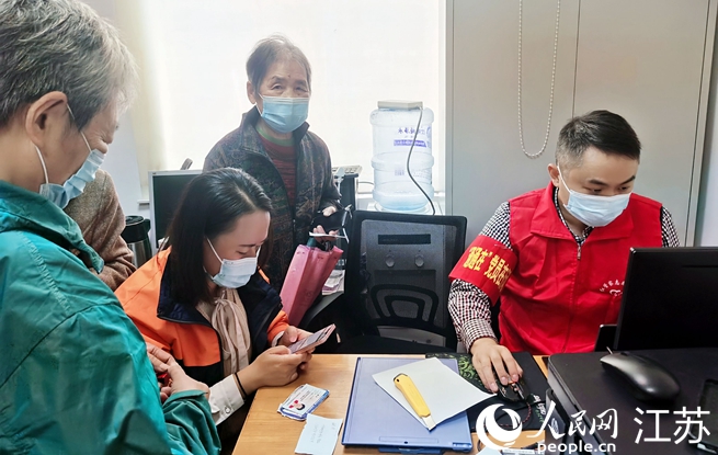 新時代文明實踐站志愿者正在為老年居民制作打印核酸采樣碼。人民網(wǎng)記者王繼亮攝