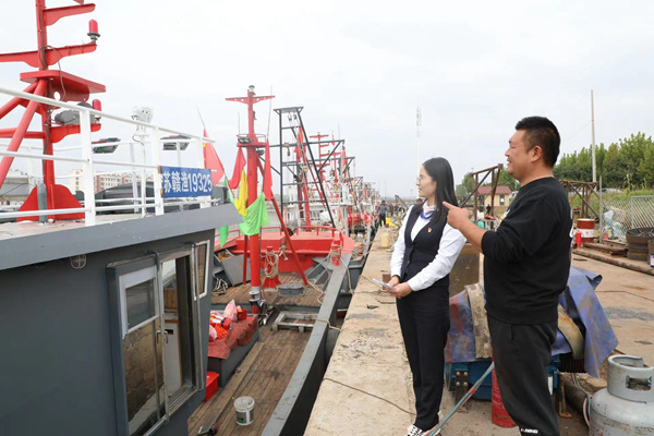 海頭漁港船主老楊向連云港中行客戶經(jīng)理介紹企業(yè)發(fā)展情況。連云港中行供圖