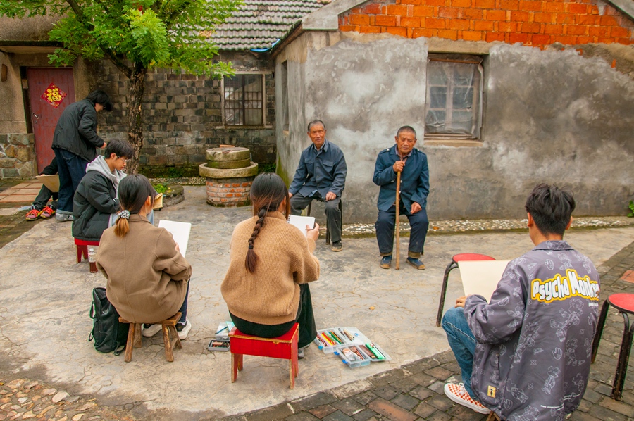 南藝師生為村民畫像。浦口區(qū)委宣傳部供圖