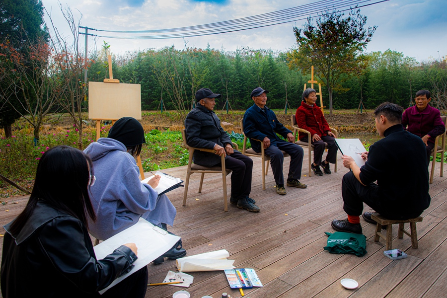 南藝師生為村民畫像。浦口區(qū)委宣傳部供圖