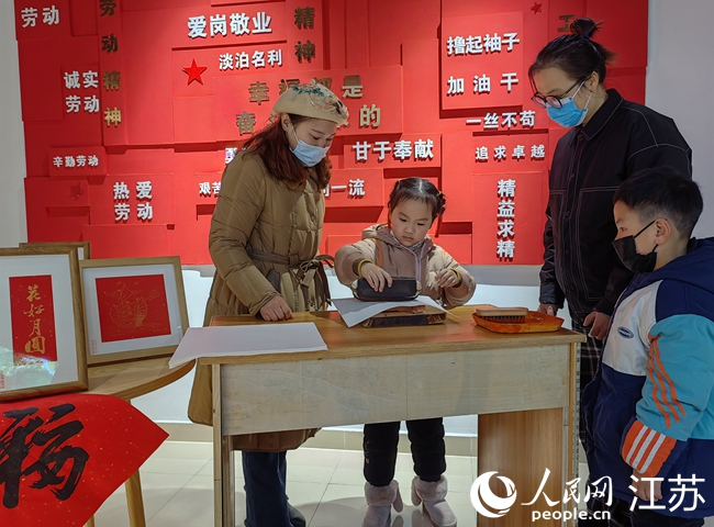 非遺傳承人指導(dǎo)孩子制作年畫。人民網(wǎng) 張玉峰攝