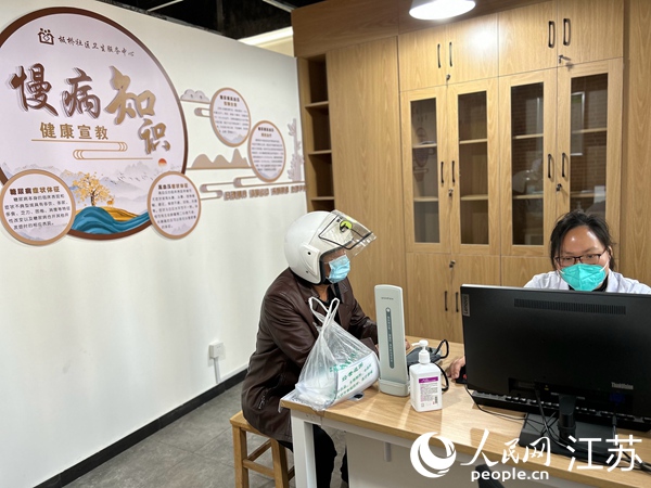 李愛平（右）接受患者咨詢。人民網(wǎng) 顧姝姝攝