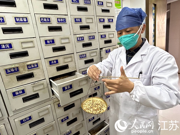 藥師在藥柜間抓藥、稱重。人民網(wǎng) 顧姝姝攝