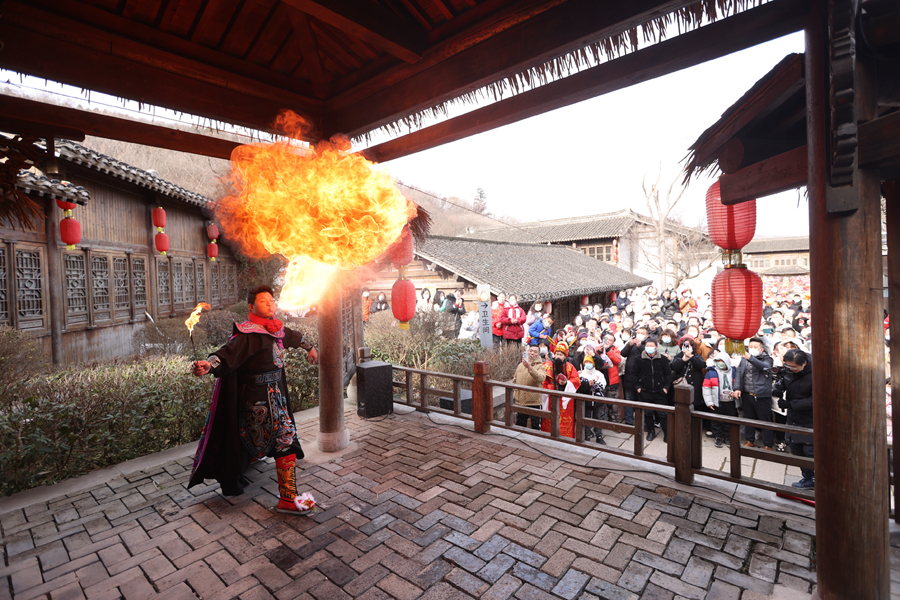 寶華山千華古村內，游客觀賞傳統(tǒng)雜技噴火表演。句容市文體廣電和旅游局供圖