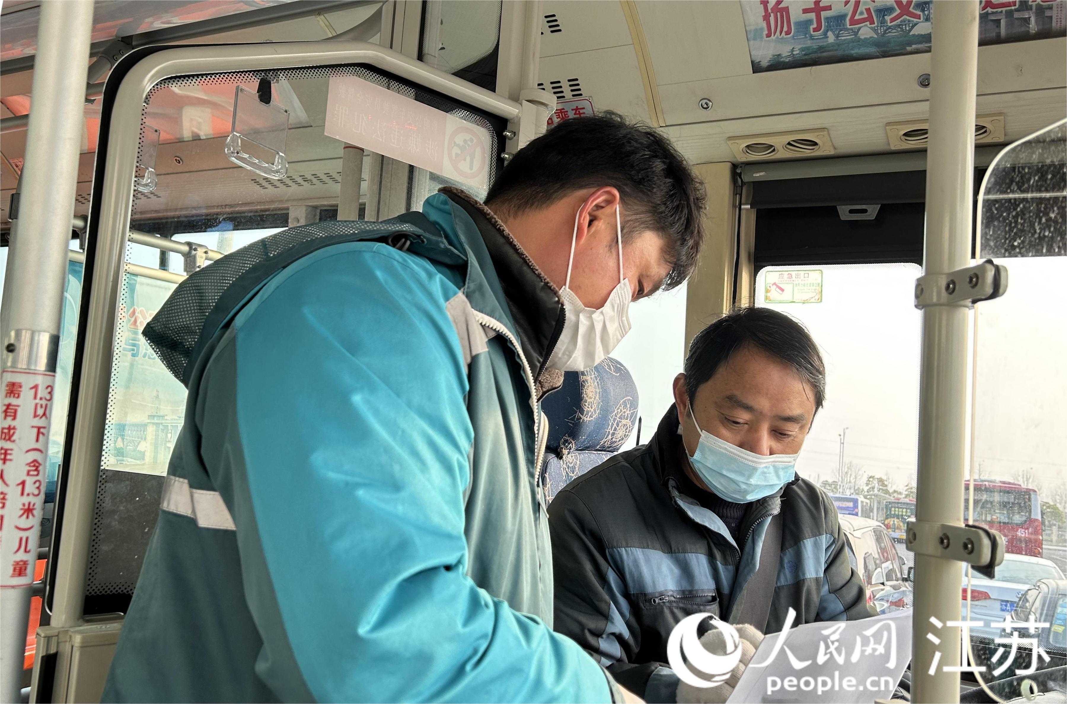 快遞攬投員將郵袋交由公交駕駛員簽收。人民網 王丹丹攝