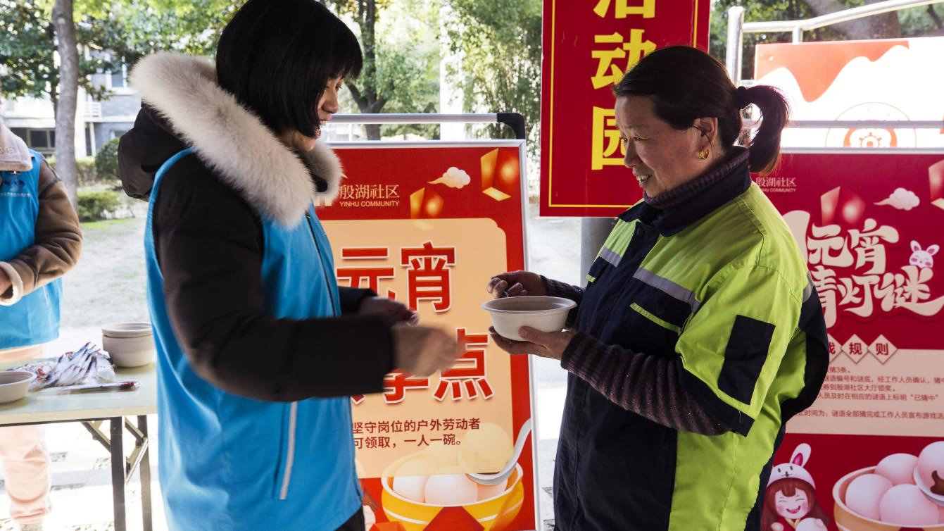 戶外工作者在“共享元宵點(diǎn)”領(lǐng)取湯圓。 丁右晨攝