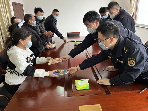 圖為城管隊(duì)員向兒童贈(zèng)書。六合城管局供圖