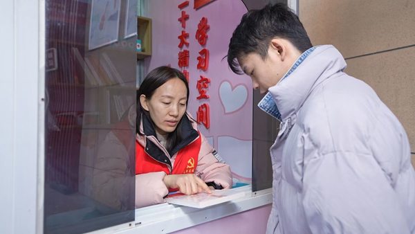 志愿者向居民分發(fā)學(xué)習(xí)書(shū)籍。相高新供圖