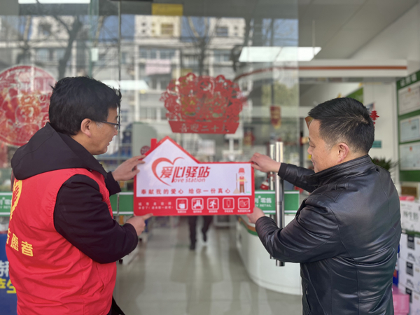 志愿者和店主張貼愛(ài)心驛站標(biāo)識(shí)。江都煙草供圖