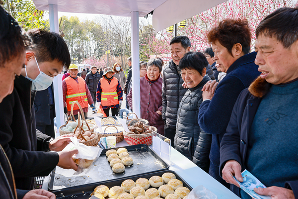 游客在西來桃花節(jié)購買西來特色農(nóng)產(chǎn)品。盛義攝