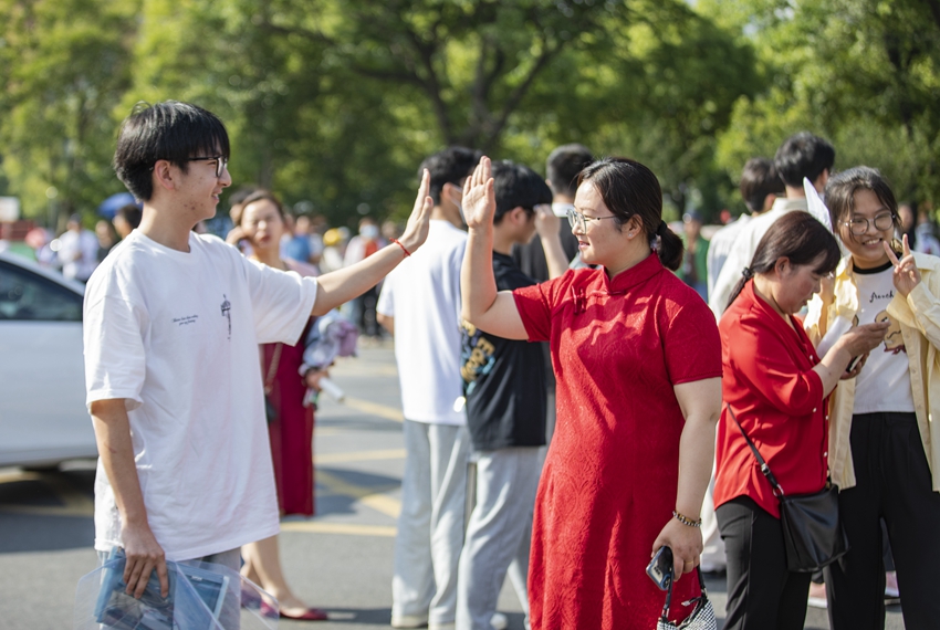 江蘇省泗洪中學(xué)考點(diǎn)，家長送考時和考生擊掌。李文攝