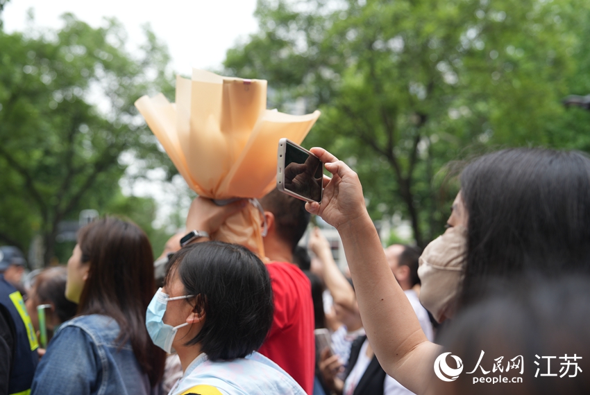 考生家長(zhǎng)正在拍攝考生出考點(diǎn)的畫面。人民網(wǎng) 李靜曄攝