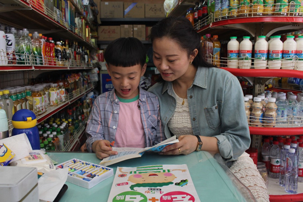 “金葉”志愿者為“一對一”結(jié)對幫扶兒童講故事。江都煙草供圖