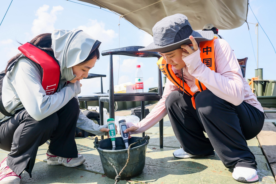 研究人員對(duì)發(fā)現(xiàn)江豚的水域進(jìn)行水質(zhì)采樣檢測(cè)。盛義攝