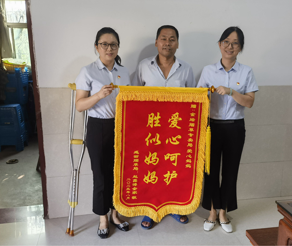 李波父親為“愛心媽媽”團(tuán)隊(duì)送錦旗。金壇煙草供圖