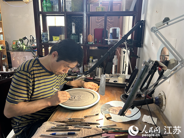 袁中平在磚雕上刻人物肖像。人民網(wǎng) 王丹丹攝