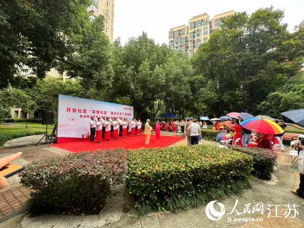 居民冒雨觀看“完整社區(qū)”建設(shè)試點廣場活動。人民網(wǎng)記者 馬曉波攝