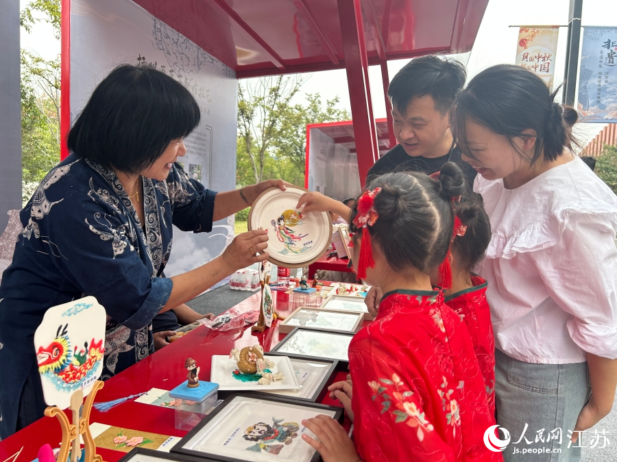 非遺傳承人向游客介紹面塑技藝。人民網(wǎng) 王丹丹攝