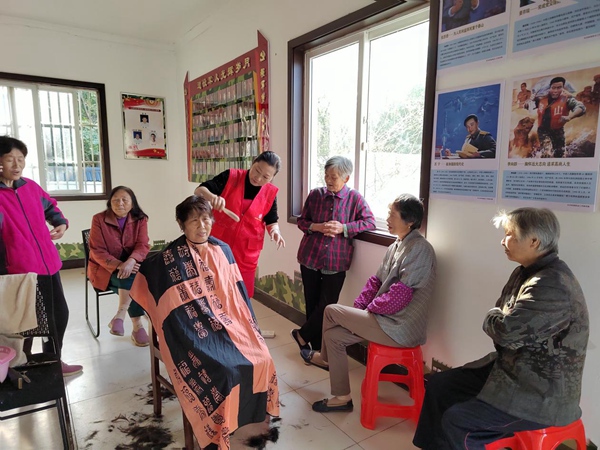 10月23日，江寧區(qū)祿口街道上穆社區(qū)新時(shí)代文明實(shí)踐站內(nèi)，志愿者為老人理發(fā)。江寧區(qū)委宣傳部供圖
