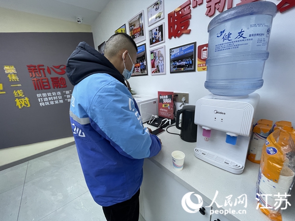 外賣配送員在驛站內(nèi)充電、休息。人民網(wǎng) 王丹丹攝