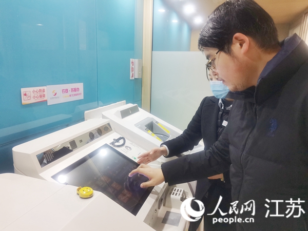 溧水農(nóng)商行工作人員在“蘇服辦”網(wǎng)點(diǎn)幫助群眾使用便民設(shè)施。人民網(wǎng) 趙登巖攝