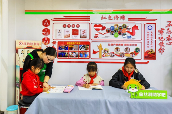 店員為留守兒童輔導作業(yè)。寶應煙草供圖