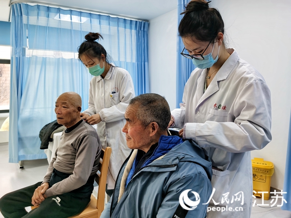 醫(yī)護人員正在對塵肺病患者實施電針康復(fù)療法。人民網(wǎng)記者 王繼亮攝