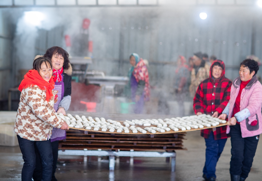 村民搬運剛剛制作好的年糕。周社根攝