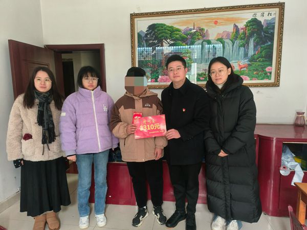 志愿者們?yōu)槔Ь硨W(xué)童送慰問金與自發(fā)捐款。寶應(yīng)煙草供圖