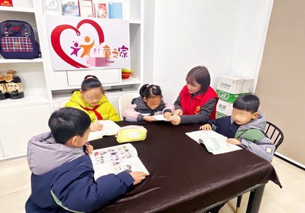巾幗志愿者為留守兒童輔導(dǎo)作業(yè)。江都煙草供圖