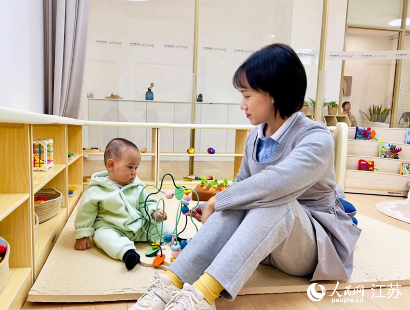 西城·晨星托育園老師陪同孩子玩耍。人民網(wǎng)記者 馬曉波攝
