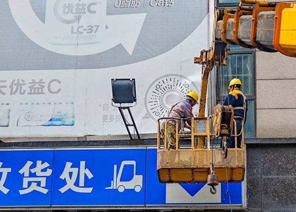 工人清理戶(hù)外破損廣告。六合區(qū)城管局供圖