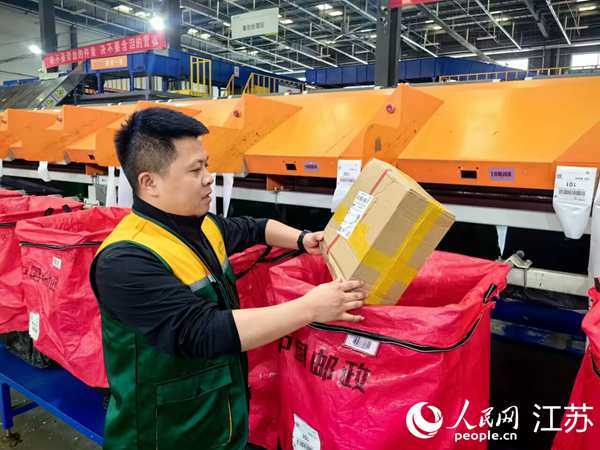 吳愛(ài)軍現(xiàn)場(chǎng)調(diào)度郵件寄遞。人民網(wǎng) 黃啟源攝