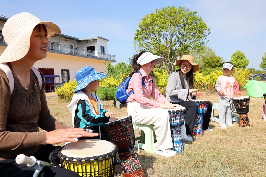 游客在草坪音樂(lè)會(huì)體驗(yàn)非洲鼓演奏。朱其攝