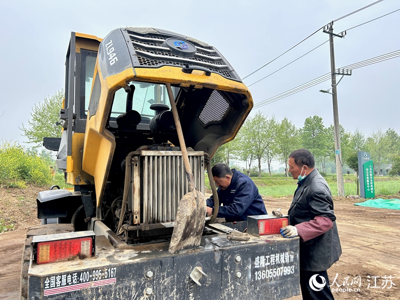 農(nóng)機手對裝載機進行機械保養(yǎng)。人民網(wǎng) 王丹丹攝