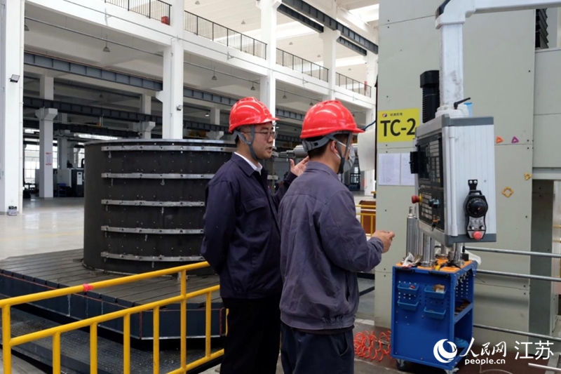 南通啟東高新區(qū)內(nèi)“上海工匠”劉建廣與工程師討論項(xiàng)目方案。人民網(wǎng) 王雪彤?dāng)z