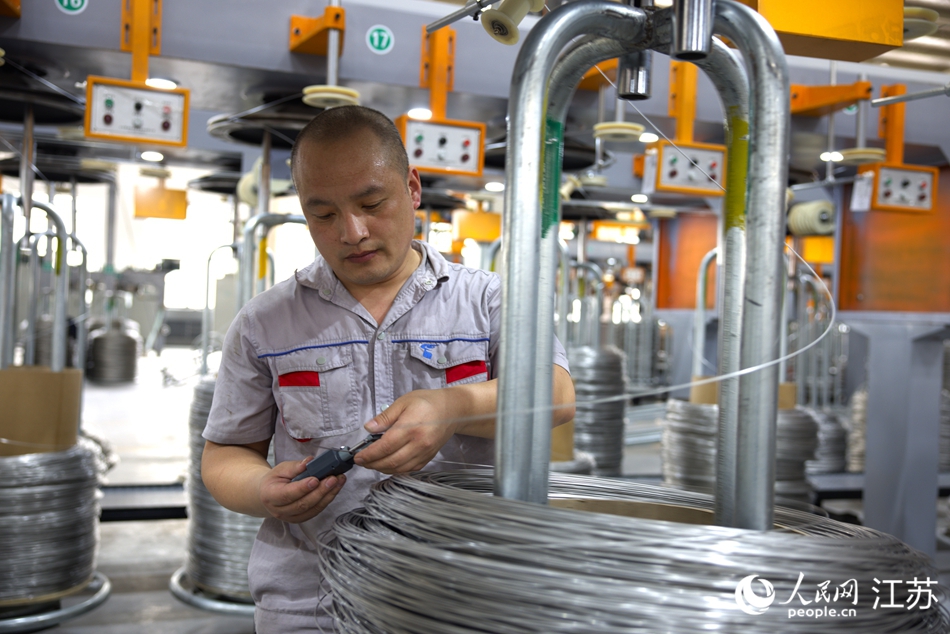 工人在抽檢不銹鋼絲線徑。人民網(wǎng) 范堯攝
